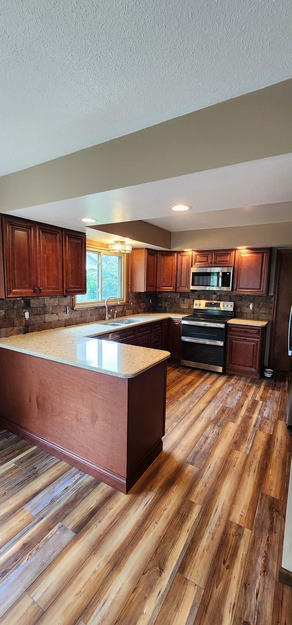 Finished cherry kitchen with quartz counters and stone backsplash by R&R